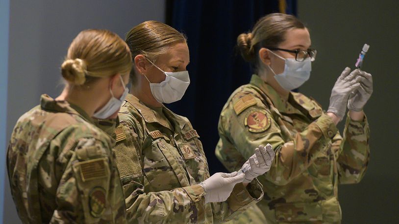 Staff Sgt. Allison Turner and Staff Sgt. Elizabeth Ciero, both with the 88th Healthcare Operations Squadron, fill syringes with the COVID-19 vaccine Jan. 8 in the Wright-Patterson Medical Center auditorium. The Airmen were preparing the syringes to vaccinate health care workers and other Phase 1 Airmen. U.S. AIR FORCE PHOTO/R.J. ORIEZ