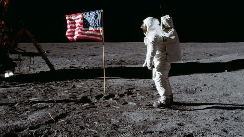 Astronaut Buzz Aldrin salutes the deployed United States flag during an Apollo 11 Extravehicular Activity (EVA) on the lunar surface. The Lunar Module (LM) is on the left, and the footprints of the astronauts are clearly visible in the soil of the Moon. Astronaut Neil A. Armstrong took this picture with a 70mm Hasselblad lunar surface camera.