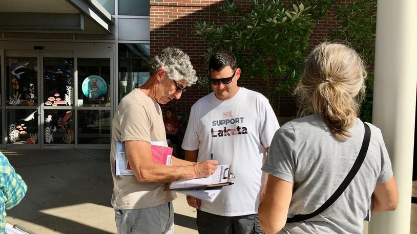 The embattled Lakota school board member Darbi Boddy, who has already been asked by colleagues to resign and was censured by them, is now the target of a growing public petition-gathering effort by critics seeking to remove her from office. Pictured is one of the leaders of the Recall Darbi Boddy effort, Alex Argo (center) gathering petition signatures recently outside of MidPointe Library. Argo is a Lakota school parent who says Boddy's many clashes with fellow members and district officials are hurting the 17,000-student district. (Photo By Michael D. Clark\Journal-News)