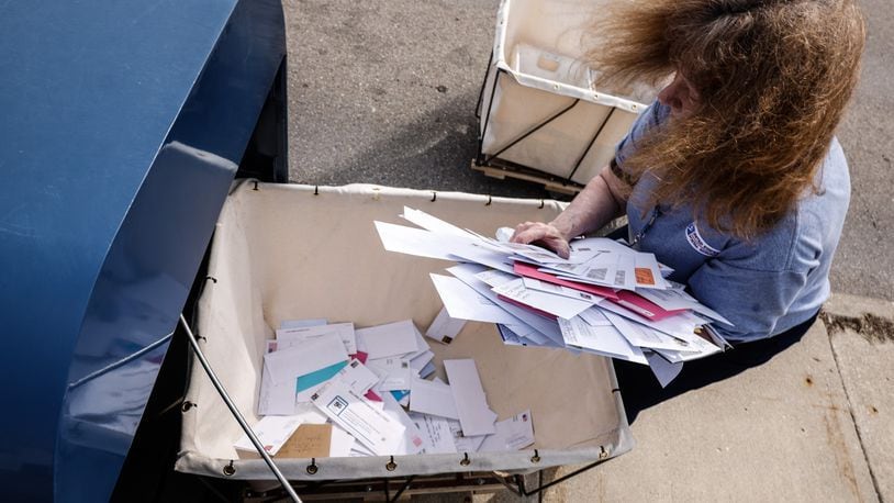 FILE PHOTO: A U.S. Postal Service worker empties a drop box in Kettering. JIM NOELKER/STAFF