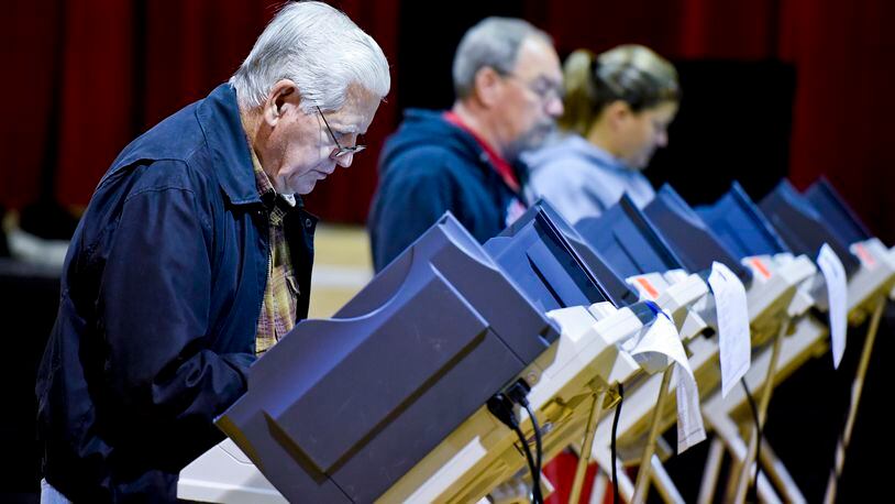 Madison Twp. resident Bob Pieratt, left, votes in the November 2015 election inside the Auxiliary Gym building at Madison Local Schools. NICK GRAHAM/STAFF