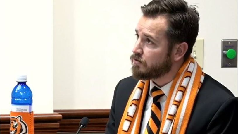Hamilton Vice Mayor wore his stripes at Wednesday's City Council meeting, with a team scarf, striped tie and a Bengals coozie around his bottle of Hamilton water. His house also is decorated in honor of the team. MIKE RUTLEDGE/STAFF