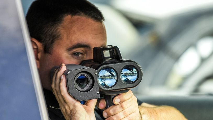 New Miami Police Officer Mark Bennett uses their Lidar photo laser speed enforcement camera along US 127 Wednesday, Nov. 30 in New Miami. A court hearing regarding the old freestanding speed cameras previously used by New Miami is scheduled for Dec. 1. NICK GRAHAM/STAFF