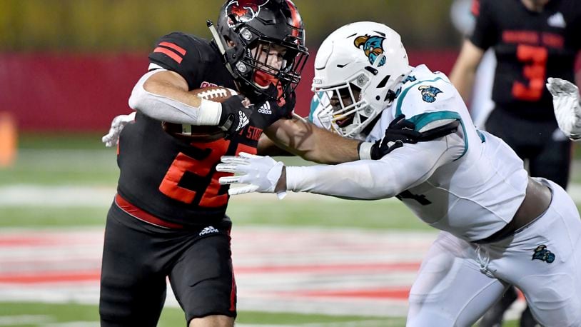 Arkansas State running back Lincoln Pare (22) tries to get past Coastal Carolina defender Jeffrey Gunter (94) during the second half of an NCAA college football game Thursday, Oct. 7, 2021, in Jonesboro, Ark. (AP Photo/Michael Woods)