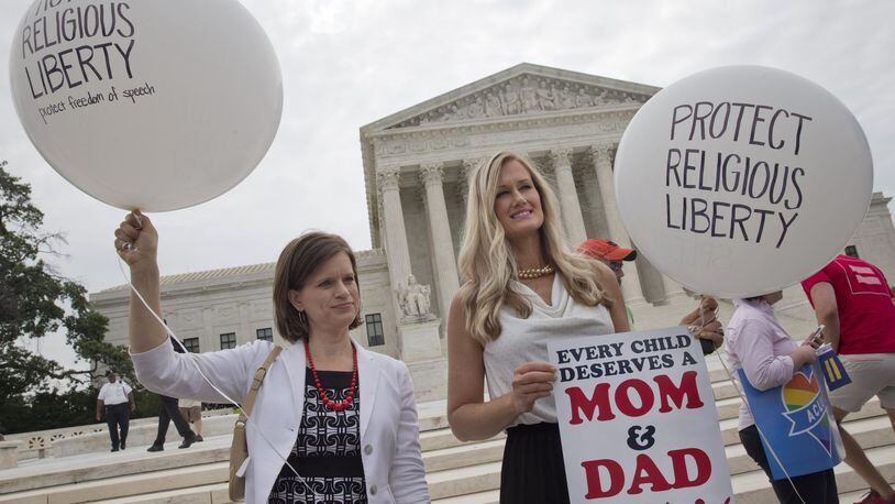 Jennifer Marshall, with the Heritage Foundation, and Summer Ingram, with the Congressional Prayer Caucus Foundation, who said they support “traditional marriage” hold balloons that says “protect religious liberty” outside of the Supreme Court Friday June 26, 2015, in Washington, before the court declared that same-sex couples have a right to marry anywhere in the US. (AP Photo/Jacquelyn Martin)