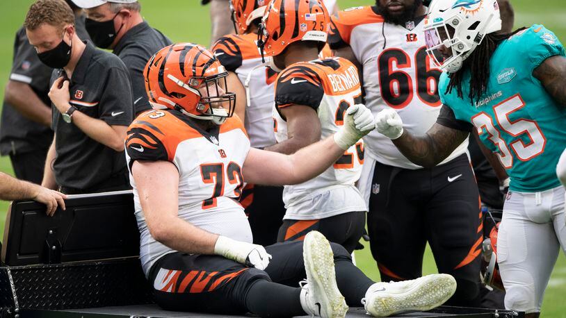 Miami Dolphins safety Kavon Frazier (35) bump fists Cincinnati Bengals offensive tackle Jonah Williams (73) who was injured and carted off the field during an NFL football game, Sunday, DEC. 6, 2020, in Miami Gardens, Fla. (AP Photo/Doug Murray)