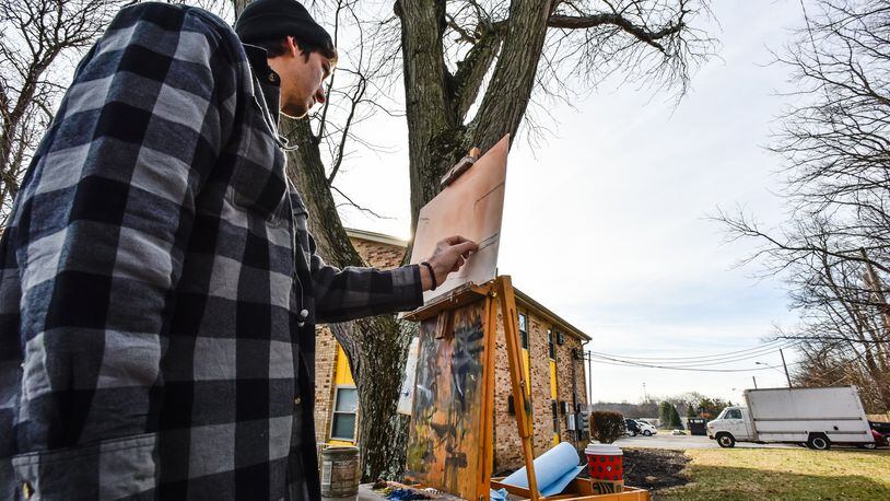 Artist Nathaniel Flanagan works on a painting along Princeton Road Thursday. Flanagan said he paints outside in all kinds of weather. The weather next week will continue the string of unseasonably warm temperatures for the winter. NICK GRAHAM/STAFF