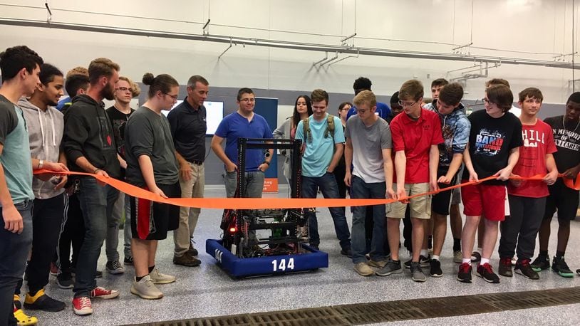 High school students from Butler Tech’s mechatronics celebrated their recently renovated and expanded learning space by using a robot they constructed to cut the ceremonial ribbon. Joining them in the celebration of the new learning space at Butler Tech’s D. Russel Lee campus in Fairfield Township were local and state politicians who praised the program. (Photo by Michael D. Clark/Journal-News)