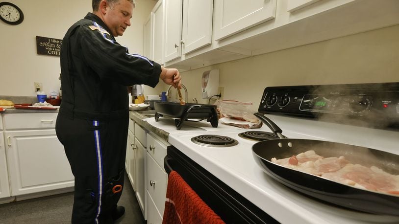 CareFlight registered nurse Mike Moyer often cooks bacon for fellow employees during his morning shift at the CareFlight hangar at Warren County Airport. NICK GRAHAM/STAFF