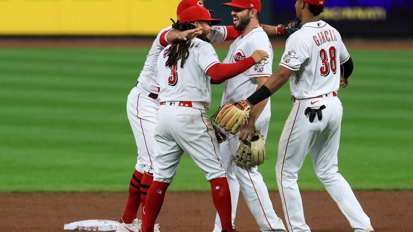Cincinnati Reds' Joey Votto, back left, Freddy Galvis, second from left, Mike Moustakas, middle, and Jose Garcia celebrate after the Reds defeated the Pittsburgh Pirates 1-0 in a baseball game Wednesday, Sept. 16, 2020, in Cincinnati. (AP Photo/Aaron Doster)