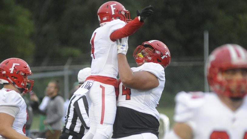 Fairfield’s Raqwon Williams (left) is hoisted by teammate Jack Carman after Williams scored on a 63-yard punt return during Friday night’s game at Northmont. The host Thunderbolts rallied for a 28-21 victory. MARC PENDLETON/STAFF