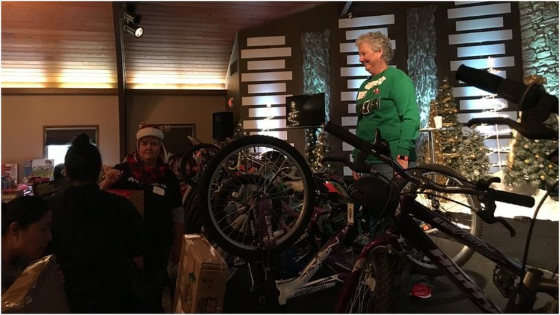 Barb Link, a volunteer with Reach Out Lakota, helped provide parents with toys for their children on Sunday, including refurbished bicycles with new biking helmets. MIKE RUTLEDGE/STAFF