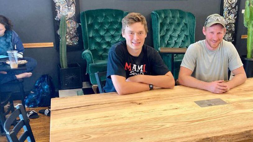 Vilppu Anttila (left) and Ryan Murphy (right) sit at their “community table” created for Kofenya Coffee House. CONTRIBUTED