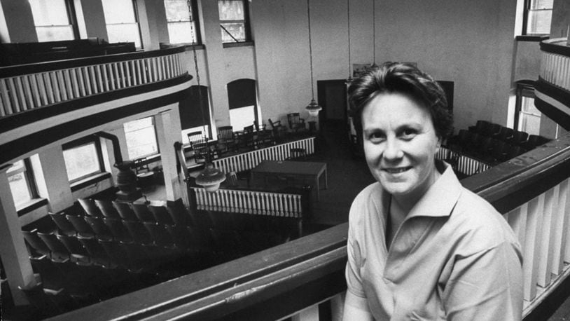 Harper Lee poses inside the Monroe County, Ala., courthouse that was the model for the courthouse in the 1962 film with Gregory Peck.