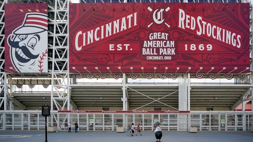 Fans stand outside of Great American Ballpark prior to a baseball game between the Cincinnati Reds and Pittsburgh Pirates, in Cincinnati, Tuesday, April.6, 2021. (AP Photo/Bryan Woolston)